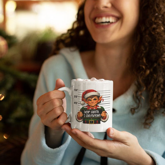 Woman holding a white Christmas mug with an elf and “Dear Santa, I can explain” design.