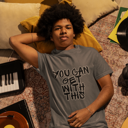 You Can Get With This graphic tee — retro music room lifestyle shot on male model in gray tee with record player and keyboard