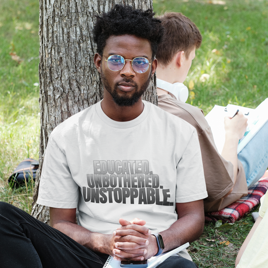 Male model in Educated Unbothered Unstoppable black tee in outdoor setting