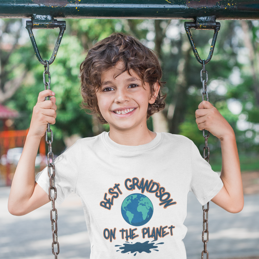 Child on a swing wearing a t-shirt with 'Best Grandson on the Planet' text