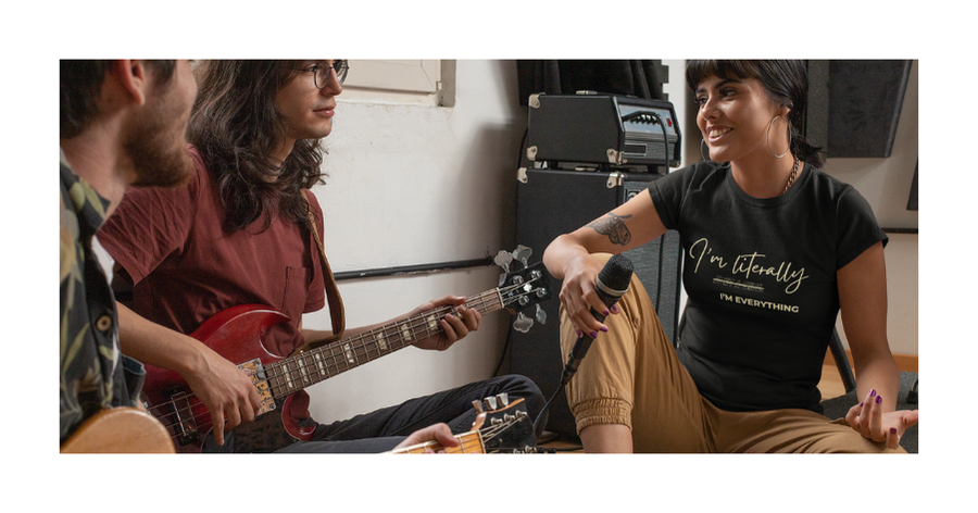Three people spending time together indoors, including one person playing an acoustic guitar and another wearing a black graphic t-shirt.