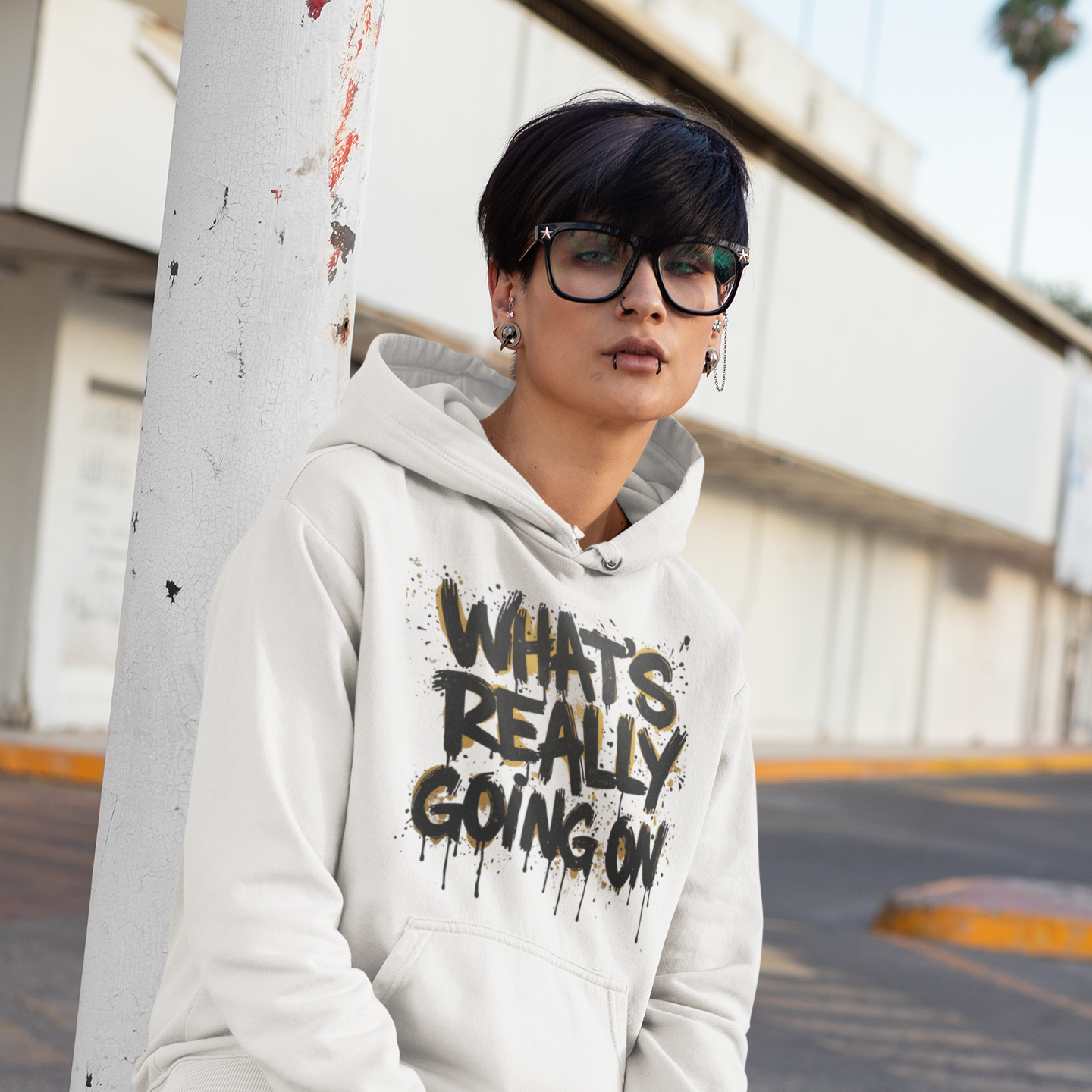 Woman wearing white statement hoodie with "What's Really Going On" graffiti drip graphic — urban streetwear pullover hoodie by Leela's Ink
