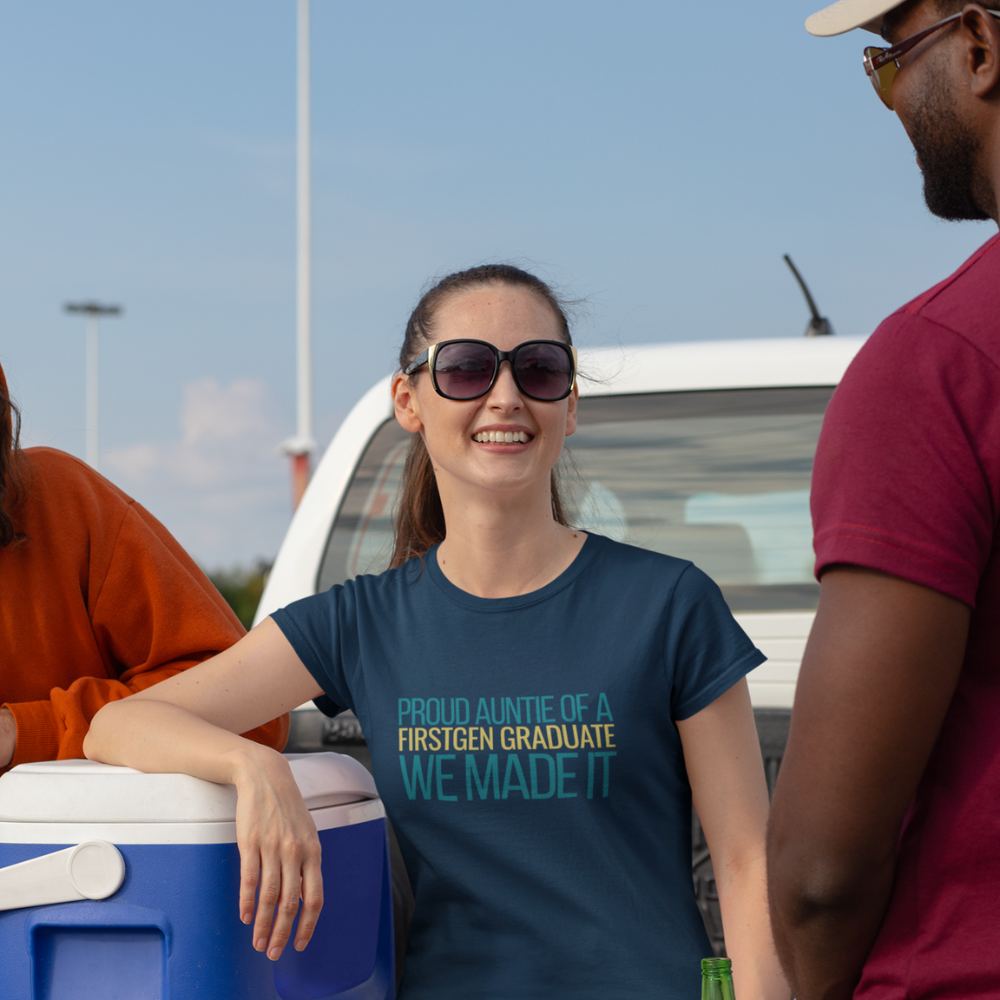 Group of friends wearing Proud Auntie First Gen Graduate navy tee at outdoor celebration