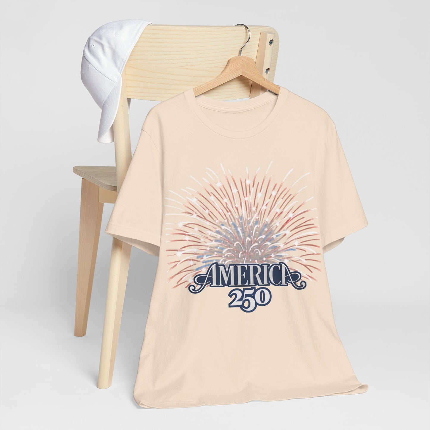 America 250 Fireworks Graphic Tee in Natural – hanger mockup showing full USA 250th anniversary fireworks sunburst design

