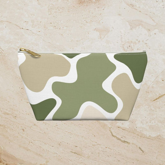 Sage green, tan, and white abstract camouflage pouch on a warm beige stone background.