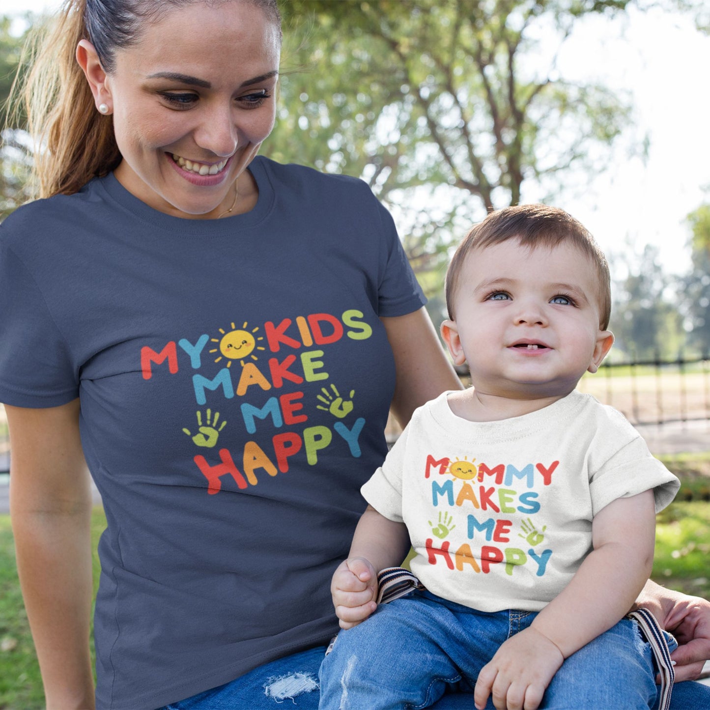 Mom holding baby both wearing matching Mommy Makes Me Happy tees in navy and white
