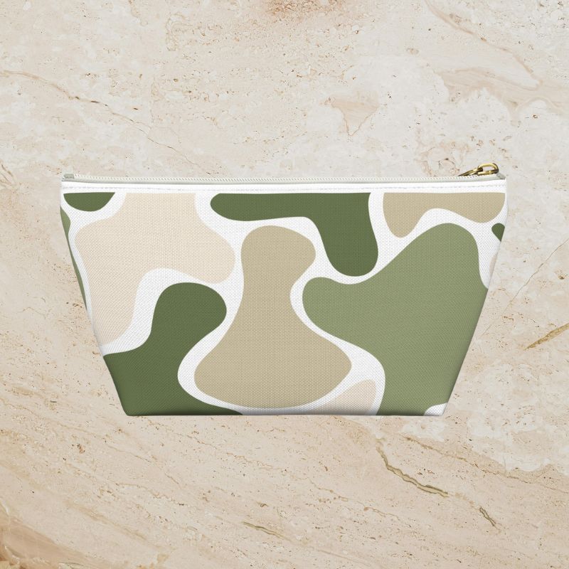 Front view of the sage, tan, and white pouch with a white zipper and gold-tone pull.