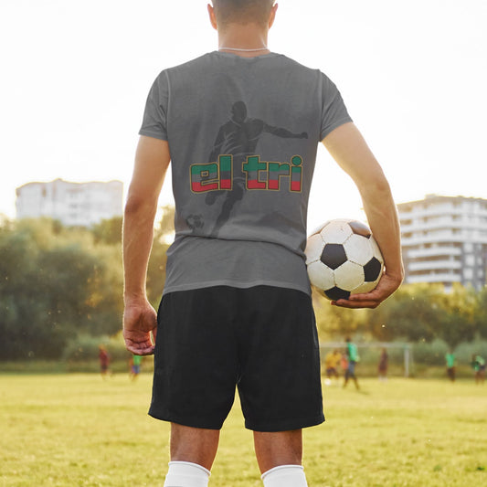 Back view of man on grass field holding soccer ball in charcoal El Tri tee showing back player silhouette graphic
