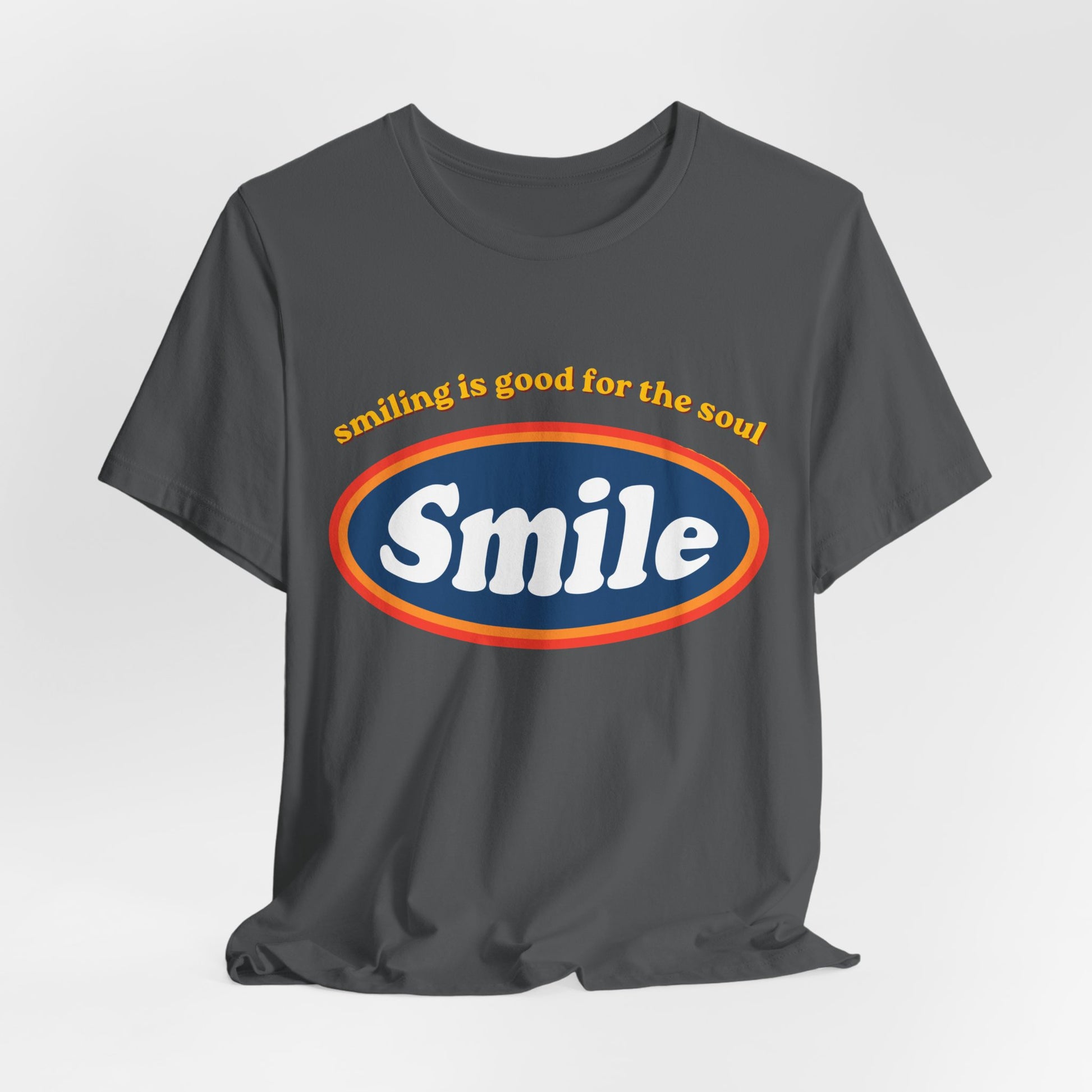 Leela's Ink Smile Retro Graphic Tee in charcoal — flat lay showing retro 'Smiling Is Good for the Soul' oval Smile graphic on unisex crew neck tee

