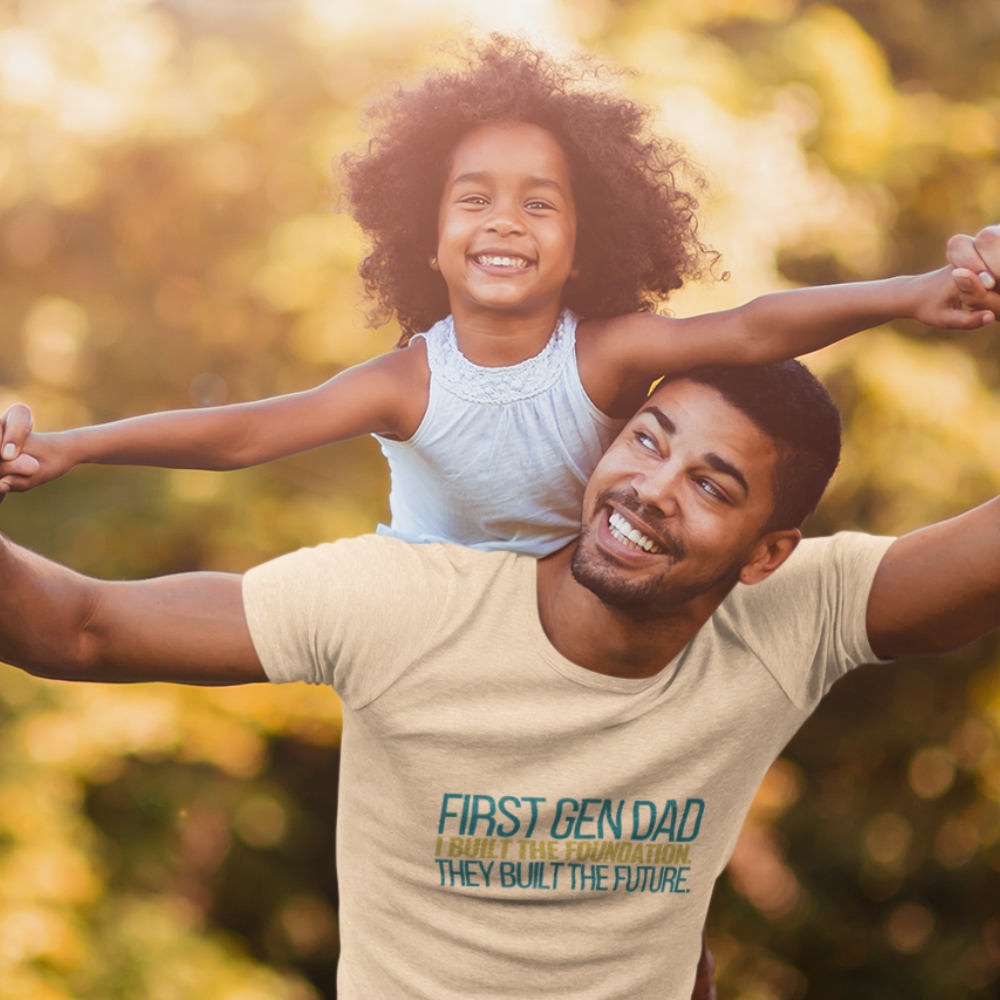 Dad wearing First Gen Dad I Built The Foundation They Built The Future soft cream tee with daughter on shoulders