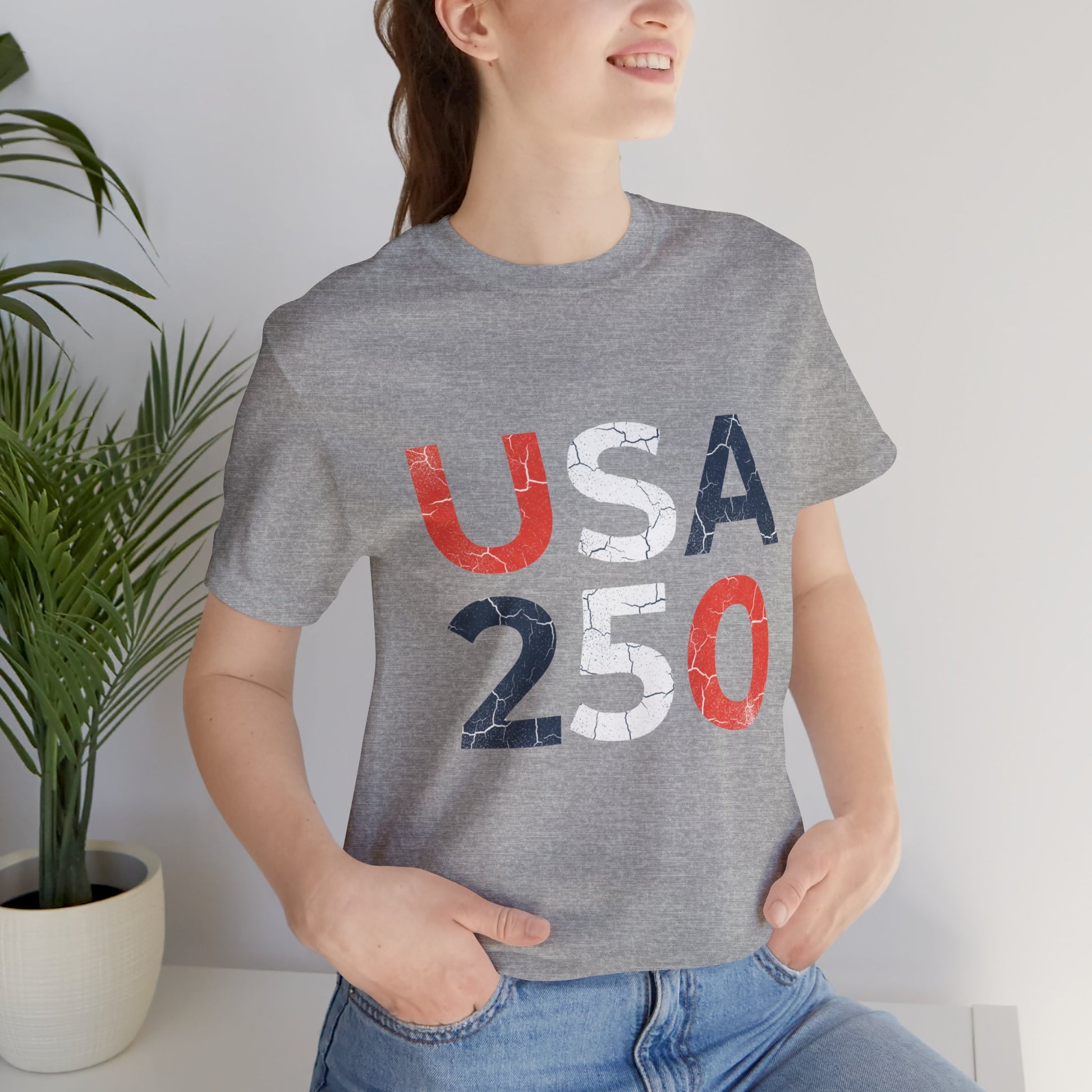 USA 250 Distressed Graphic Tee in Athletic Heather – woman wearing patriotic USA 250 distressed block letter tee indoors

