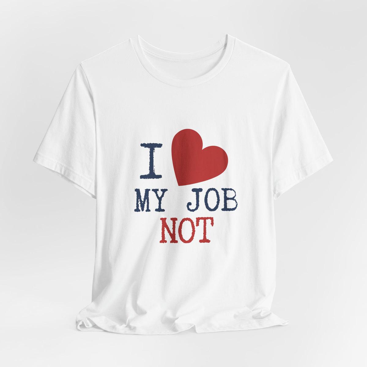 A white short-sleeve crewneck t-shirt with a graphic print that reads 'I [red heart] MY JOB NOT' in navy blue and red text, displayed on a light gray background.