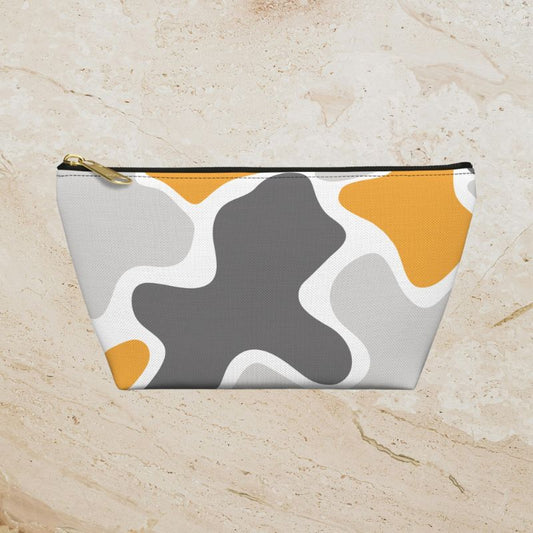 Front view of the yellow, gray, and white camouflage pouch with a black zipper and gold-tone pull.