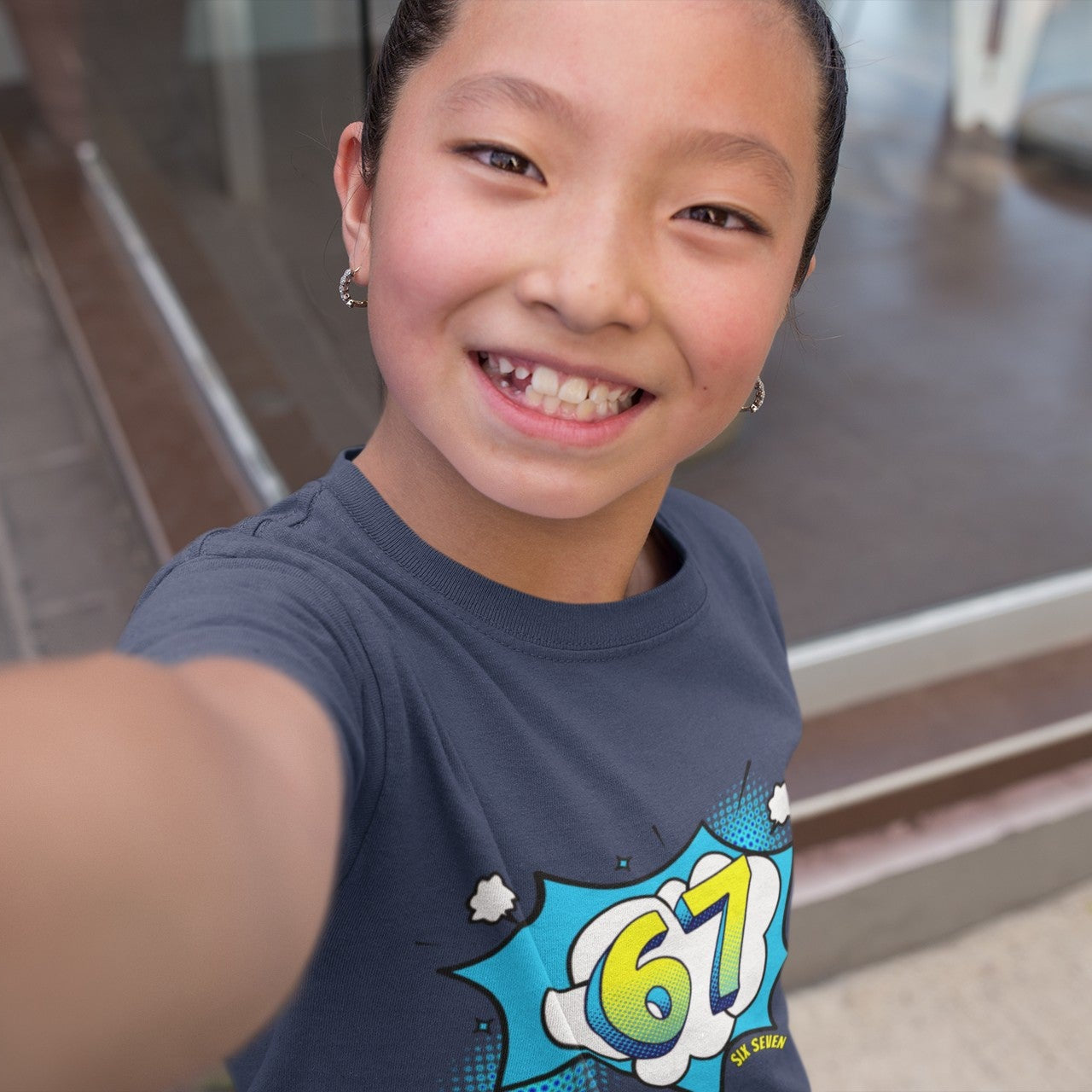 girl wearing Kids Six Seven Comic Pop Graphic T-Shirt in Red, smiling lifestyle shot