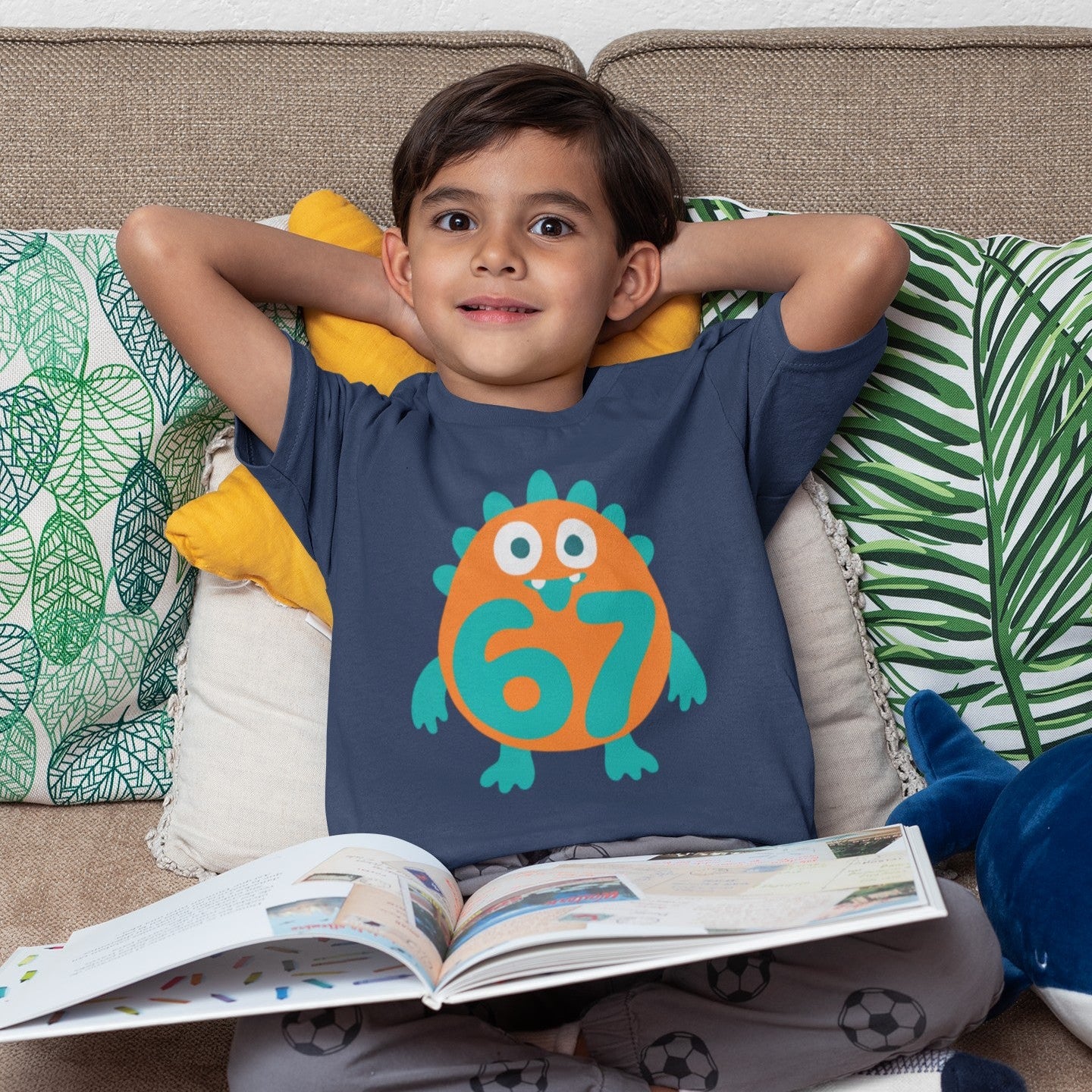Boy wearing Kids 6/7 Monster T-Shirt in Navy, sitting with a book