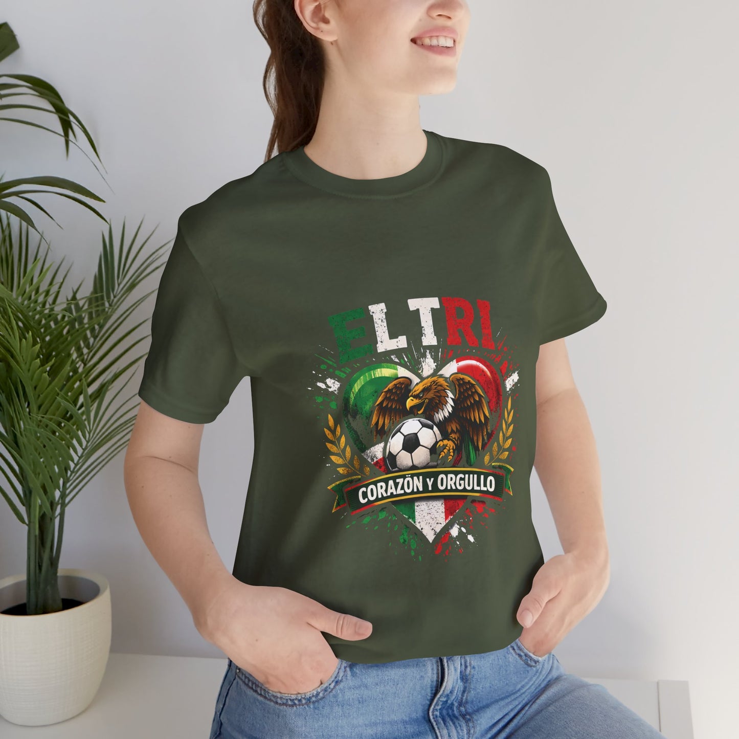 Woman wearing military green El Tri Corazón y Orgullo tee, casual outdoor lifestyle shot
