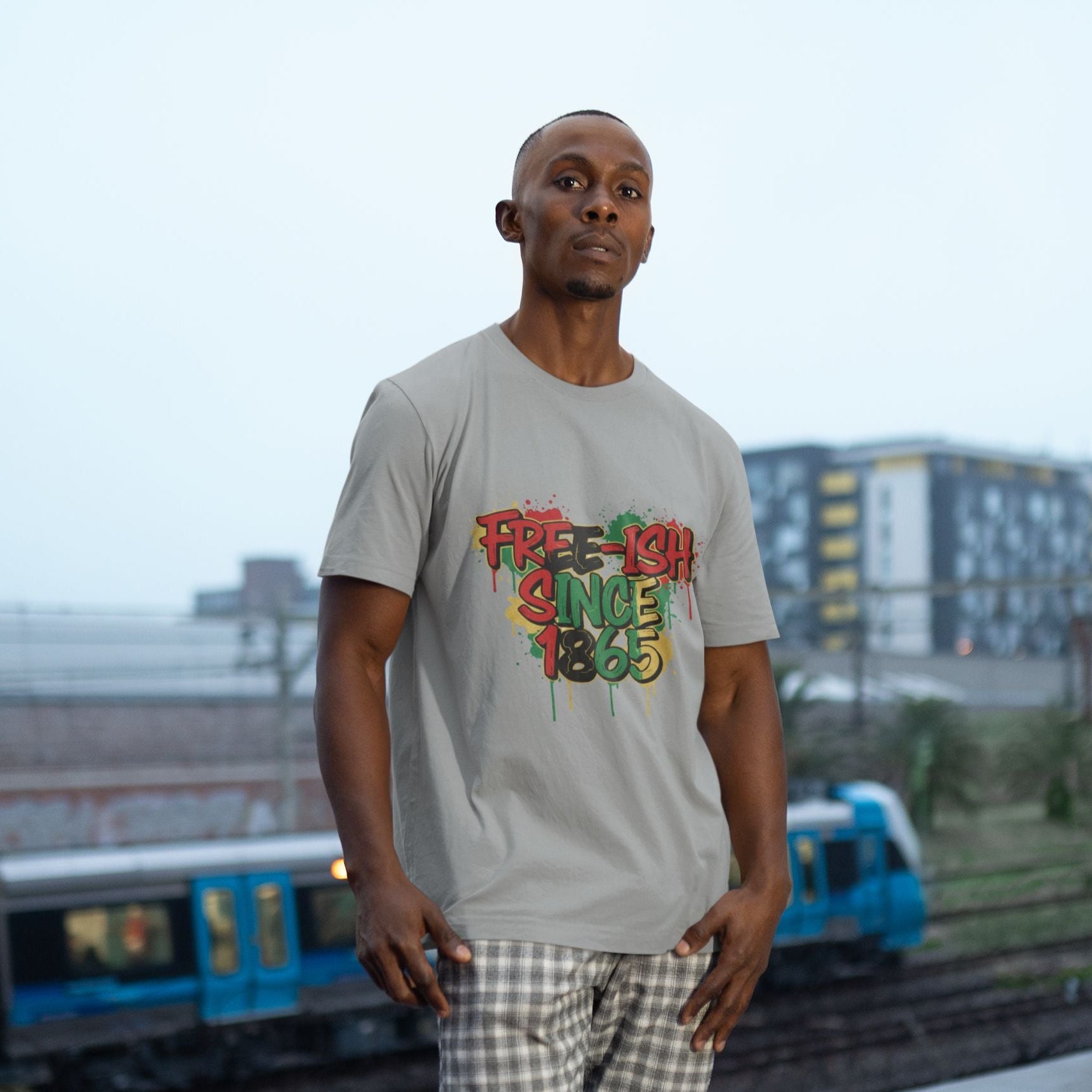 Free-ish Since 1865 Juneteenth Graphic Tee in Athletic Heather – Black man wearing bold graffiti emancipation shirt outdoors


