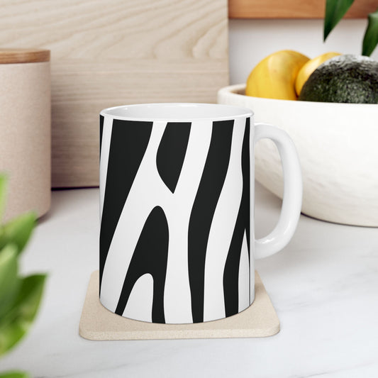 Black-and-white zebra print mug with a white handle on a coaster on a kitchen counter.