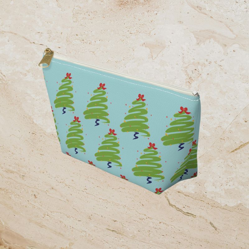 Side angle of the icy-blue pouch with green trees and red accents.