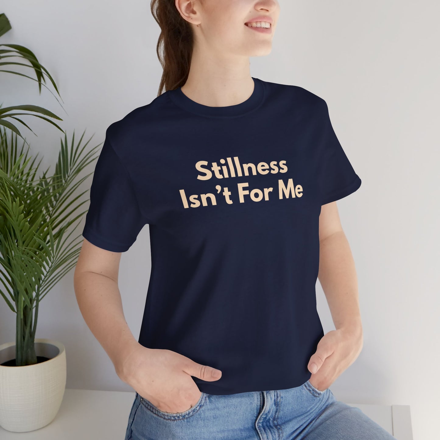 Woman wearing white Stillness Isn't For Me graphic tee — unisex wanderer travel shirt relaxed fit
