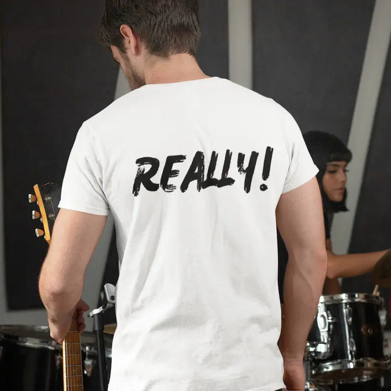A man wearing a white t-shirt with the word 'REALLY!' printed in black across the back, shown from behind in a band setting with other musicians playing instruments.