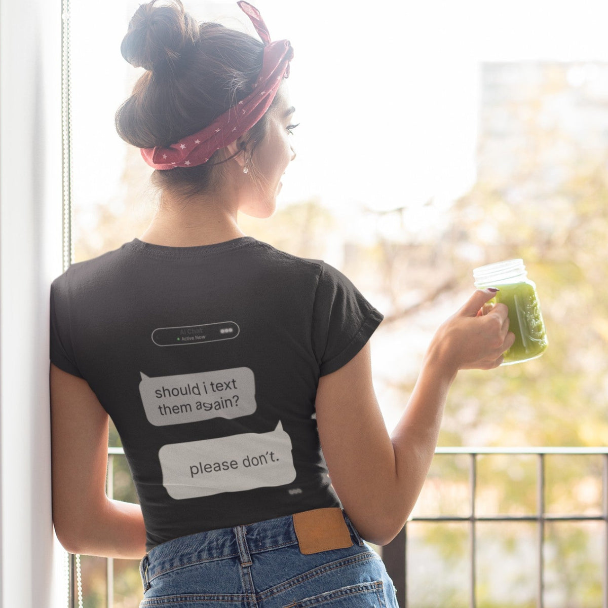 Woman on balcony showing back print of Should I Text Them Again AI chat graphic tee in black
