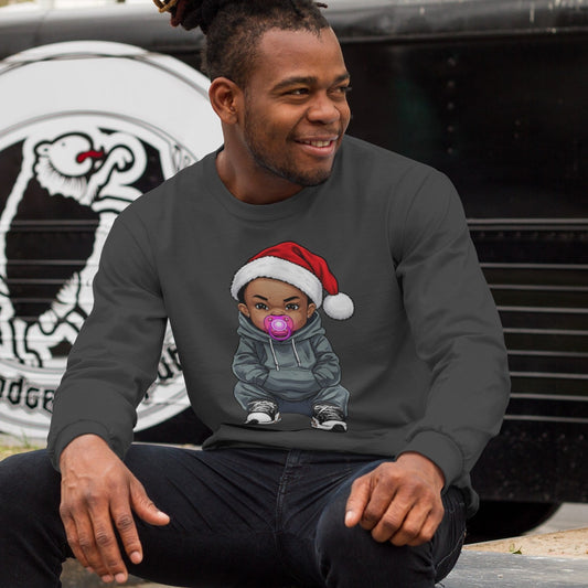 Man sitting by a food truck wearing an Uzi Baby Christmas long-sleeve t-shirt with the Uzi Baby character in a Santa hat