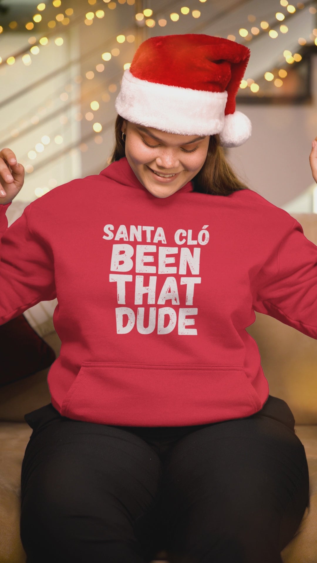 Video of a woman wearing a red Santa Cló Been That Dude hoodie and Santa hat