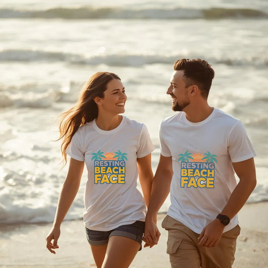 Couple walking on beach wearing matching white Resting Beach Face graphic tees — Leela's Ink

