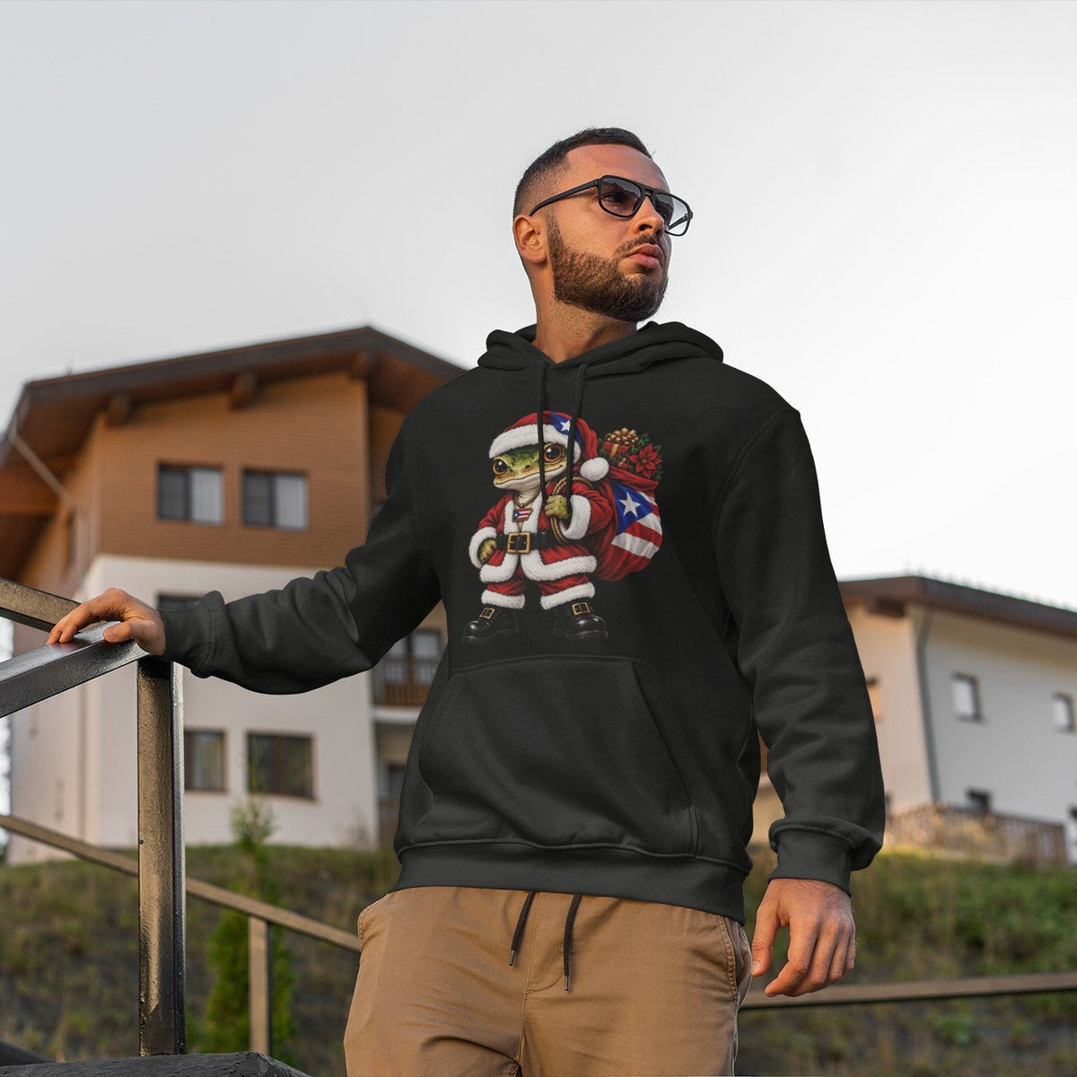 Adult wearing a dark charcoal Puerto Rican coquí Santa hoodie outdoors.