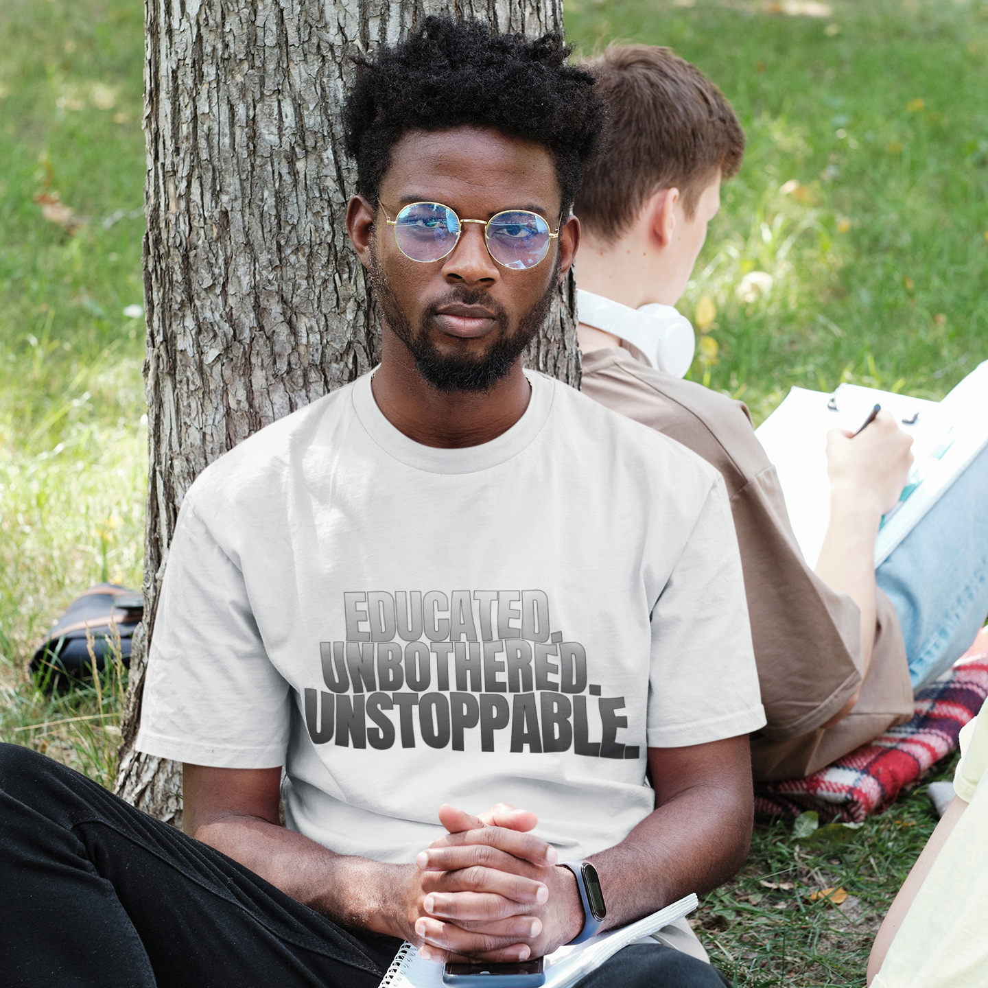 Male model in Educated Unbothered Unstoppable black tee in outdoor setting