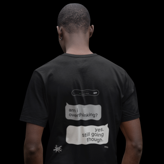 Back view of black graphic tee on dark background, 'am i overthinking? yes. still going though.' Chat Gone Wild print detail
