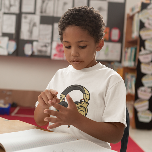 Boy wearing Kids Headphones Graphic T-Shirt in White, classroom lifestyle shot