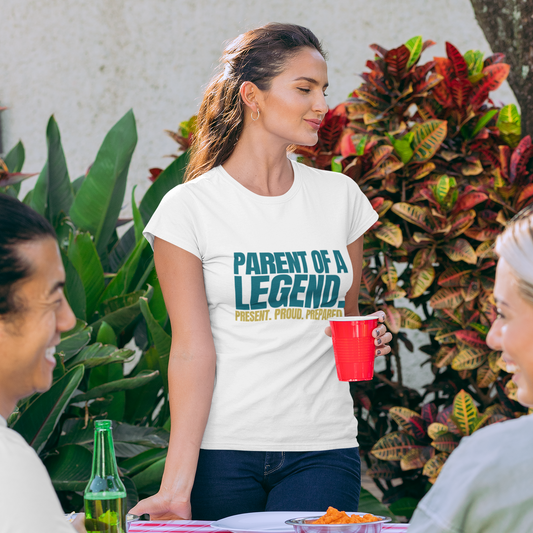 Woman wearing Parent of a Legend white tee at outdoor graduation celebration party