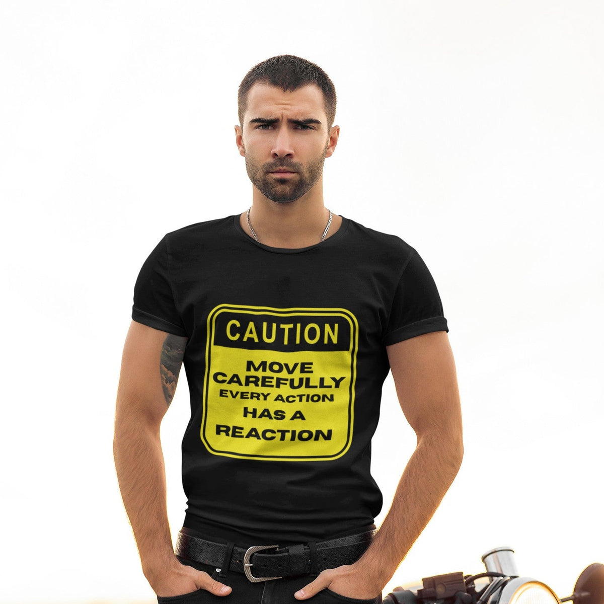 Front view of a man wearing a black t-shirt with a yellow caution sign that reads Move Carefully Every Action Has a Reaction